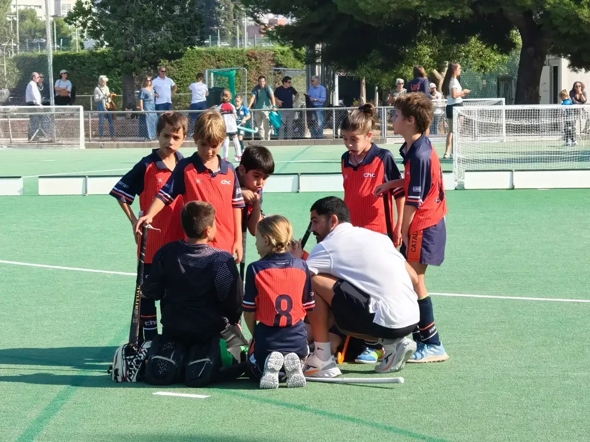 Spielerinnen und Spieler der Akademie des Catalònia HC hören ihrem Trainer zu